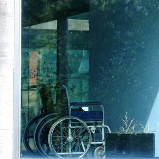 ein abgestellter Rollstuhl hinter einer Glasfassade